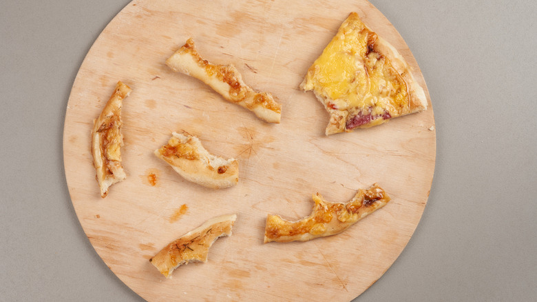 pizza crust and half slice leftovers on tray