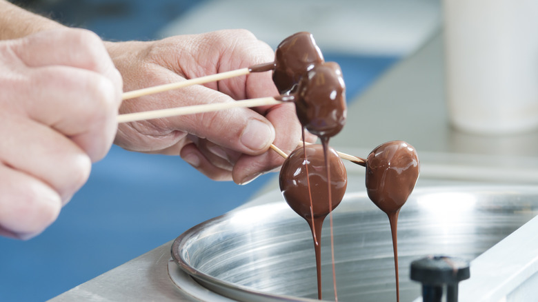 Hand dipping truffles in chocolate