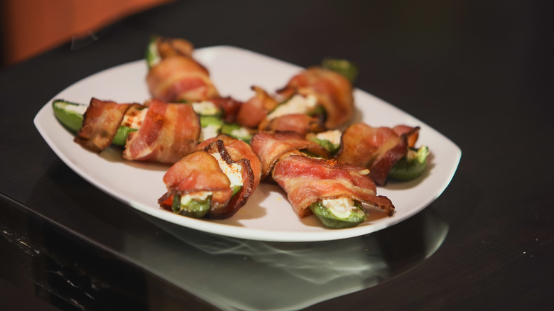 Bacon-wrapped jalapeño poppers on white plate