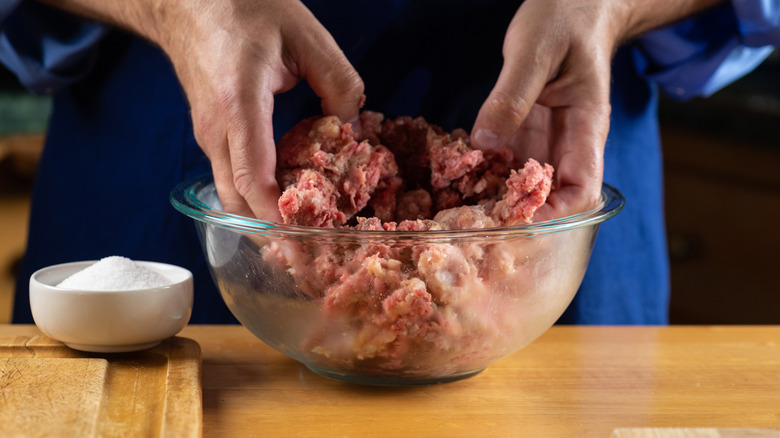 chef mixing beef in bowl