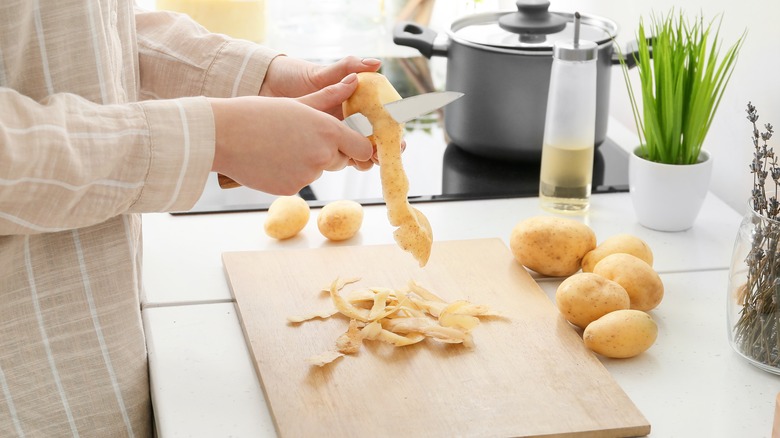 Person peeling potatoes
