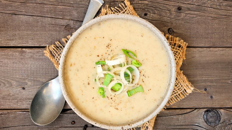 Potato and leek soup topped with raw leeks and pepper