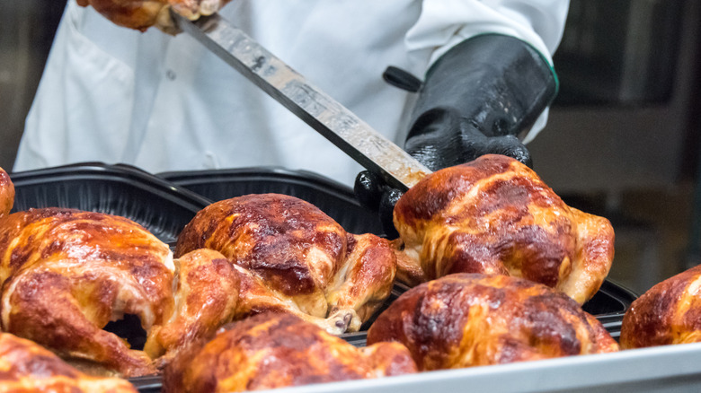 Rotisserie chickens being prepared at a grocery store