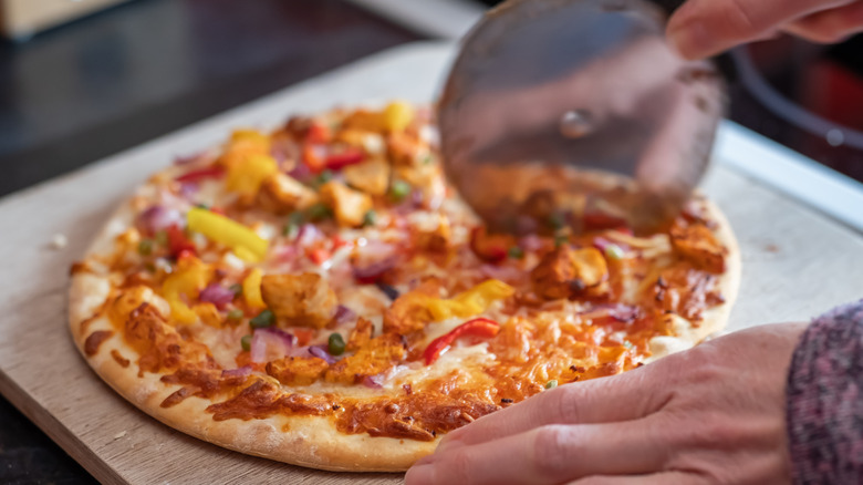 Person using pizza cutter