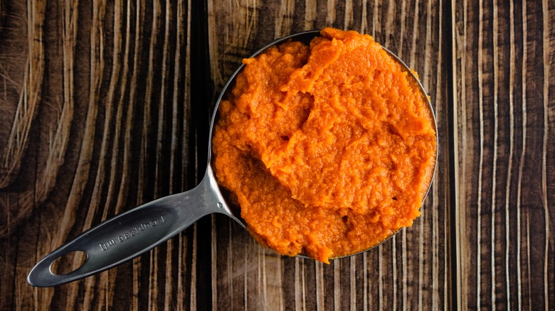 Pumpkin puree in a metal measuring cup