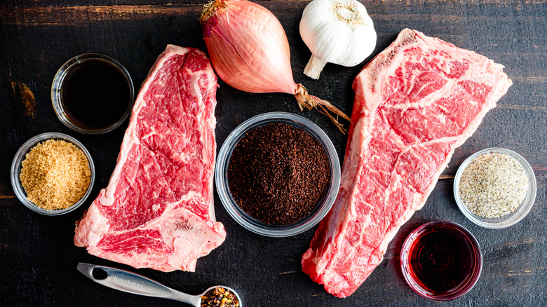 grill prep with steaks, seasonings, garlic, onion