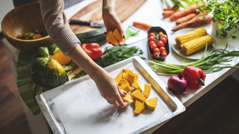 putting vegetables on a sheet pan