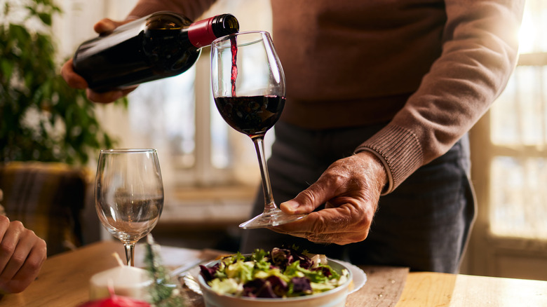 person pouring wine