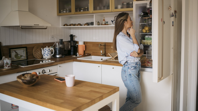 woman looking inside freezer