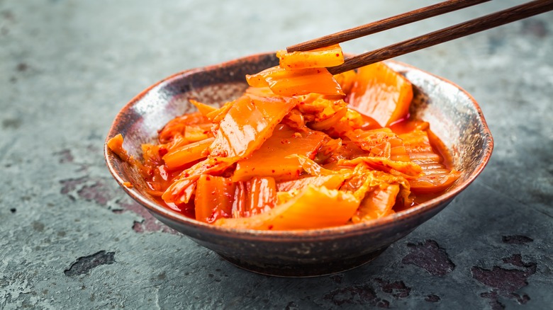 kimchi on chopsticks in bowl