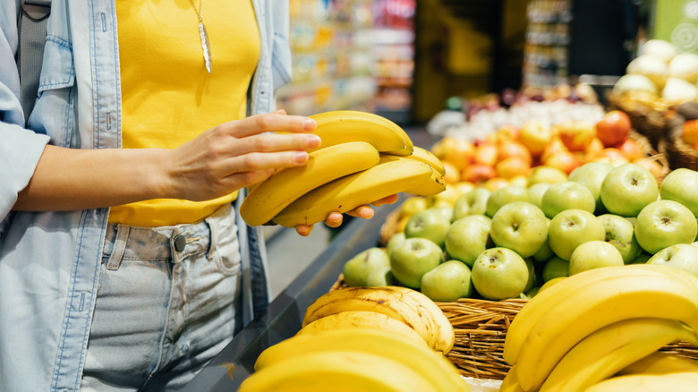 woman holding bananas at store