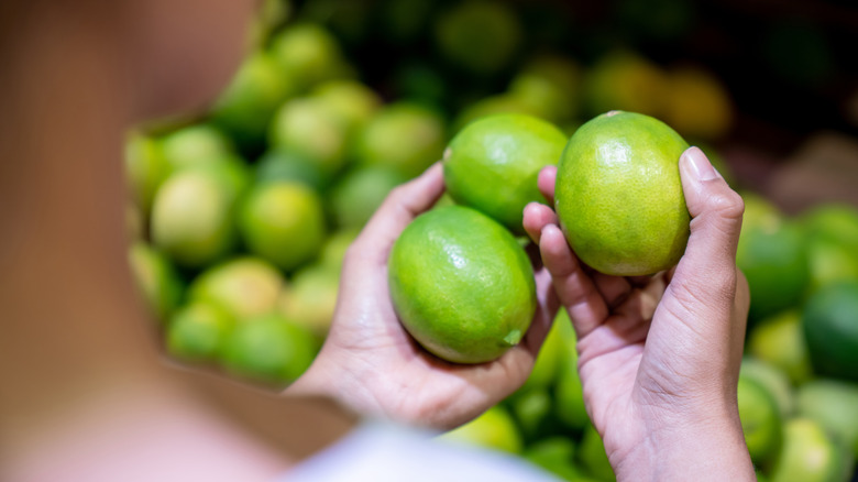 hands picking up limes