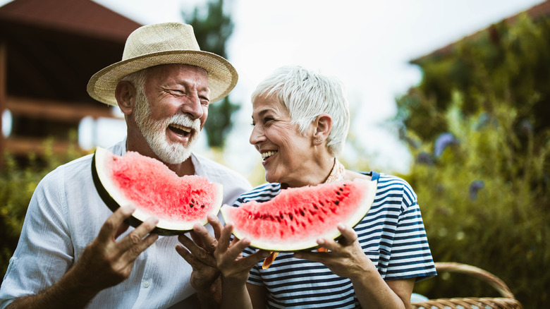 Couple eating large watermelon slices