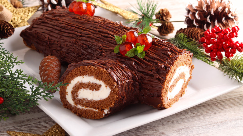 Yule log cake is displayed on a platter.