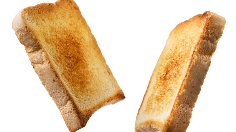 Two slices of toasted white bread on a white background