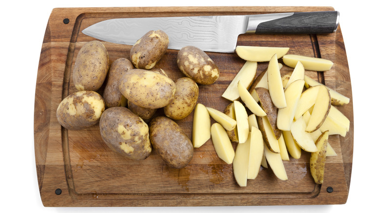 Potatoes on wooden cutting board