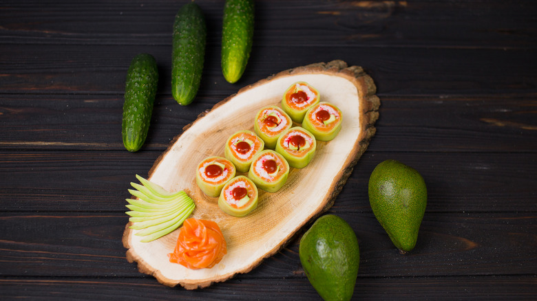 cucumber wrapped sushi rolls on wooden board