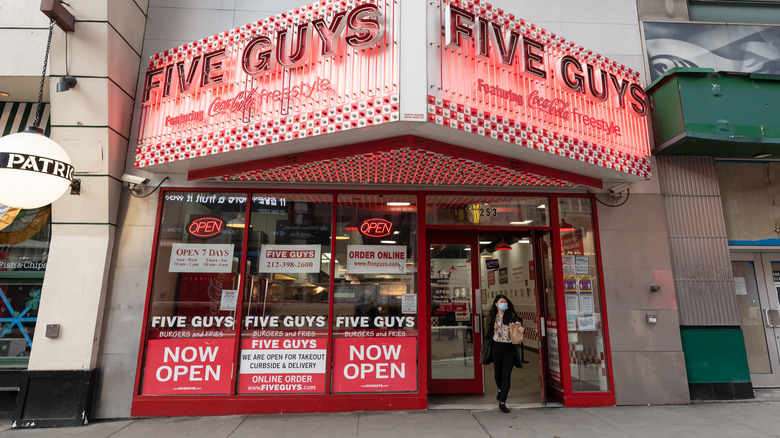 Woman exiting street front Five Guys