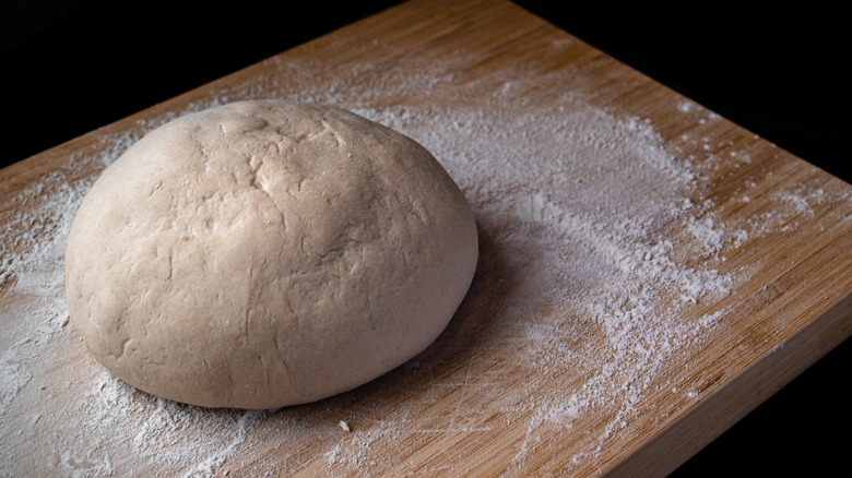 Ball of bread dough sitting on a floured surface