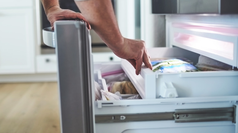 Man opening freezer drawer