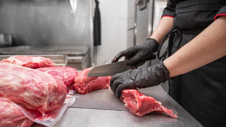 butcher cutting steaks