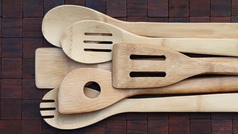 Wooden slotted spoons on tile