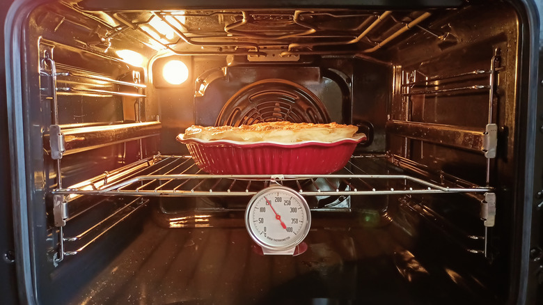 Pie in an oven with thermometer