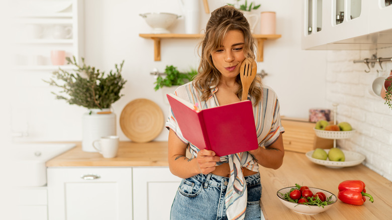 Woman reading a recipe looking perplexed