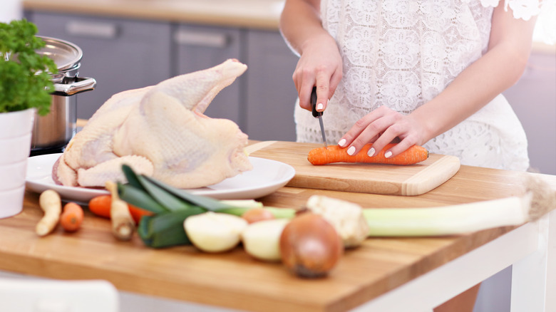 Person preparing a chicken dish