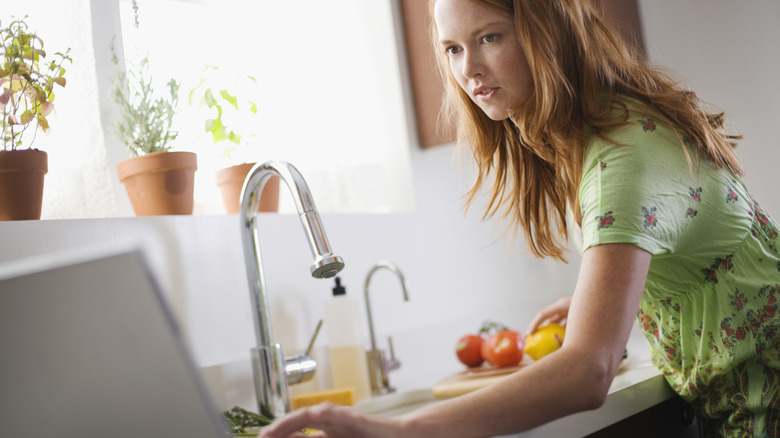 Woman checking a recipe on a laptop