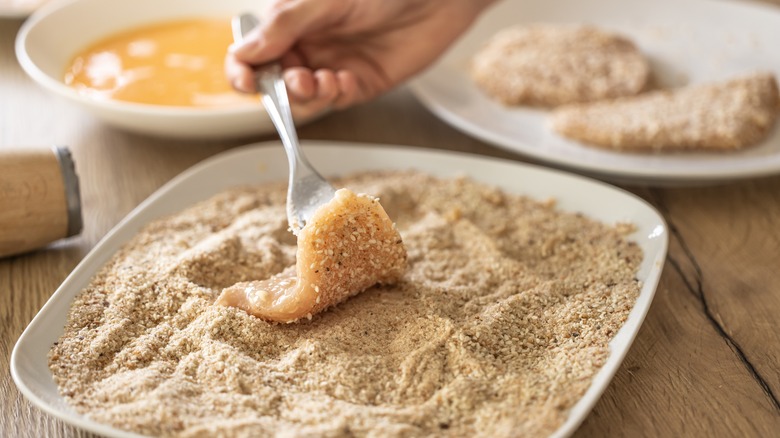 Coating raw chicken in breadcrumbs