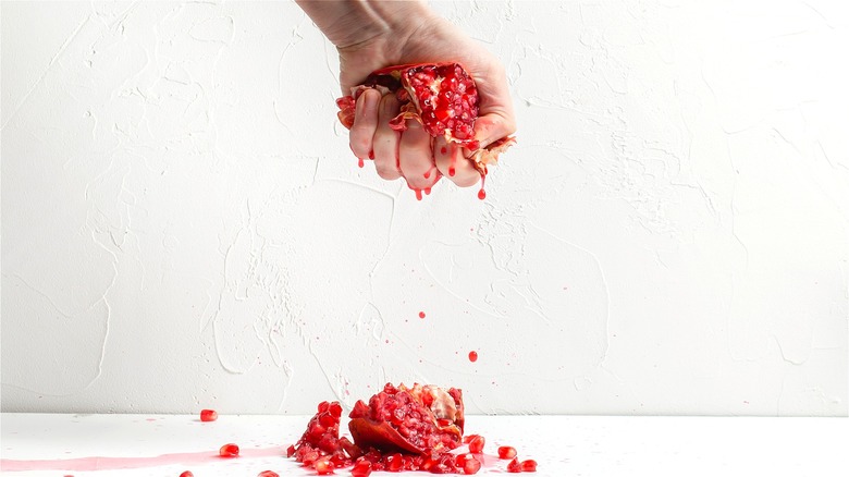 Hand squeezing pomegranate 