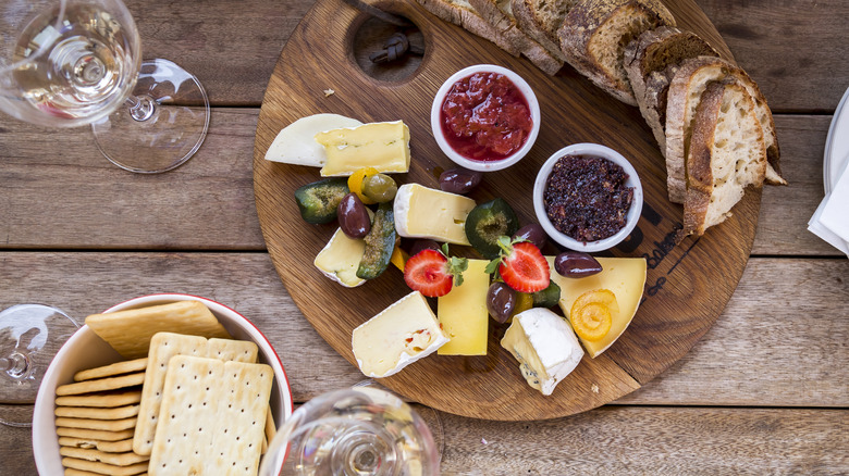 Charcuterie board with cheese, breads, and jellies