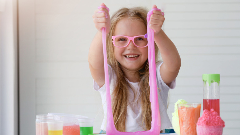 Little girl playing with pink slime