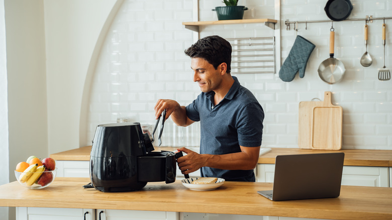 Person opening air fryer basket