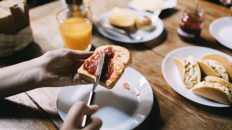 spreading jam on bread