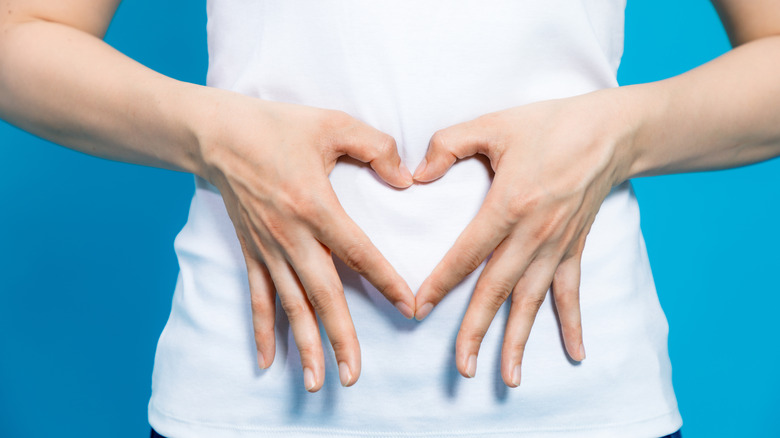 hands making a heart near stomach