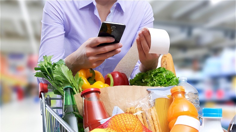 Shopper looking at grocery receipt