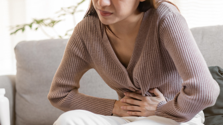 woman holding stomach in pain