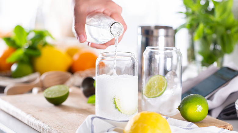 pouring seltzer water with limes