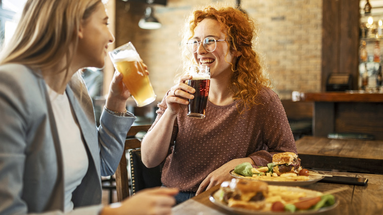 women drinking beer with burgers