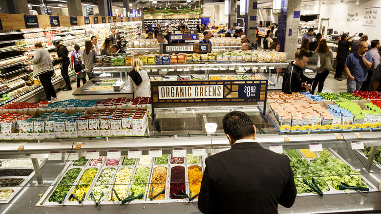 People shopping at whole foods hot bar