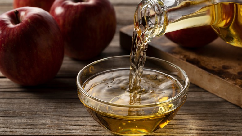 Apple cider vinegar being poured into a bowl