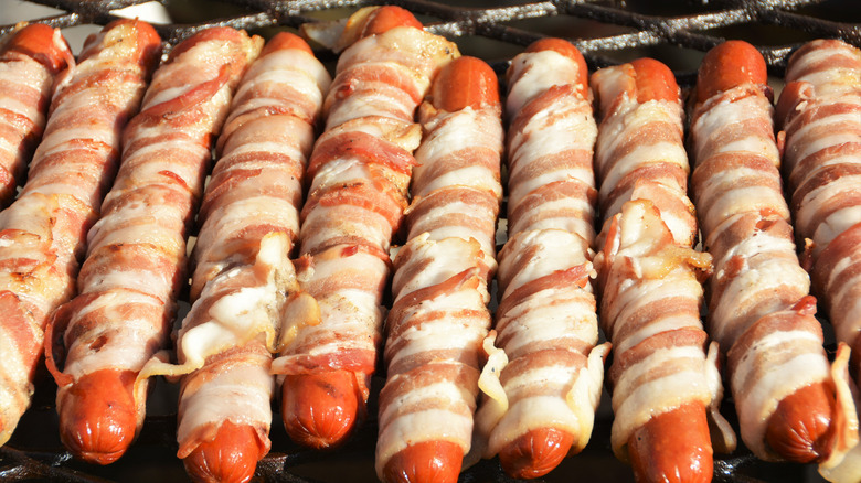 Bacon wrapped hot dogs on the grill