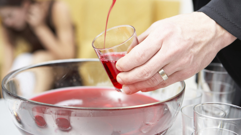 person ladling punch into cup