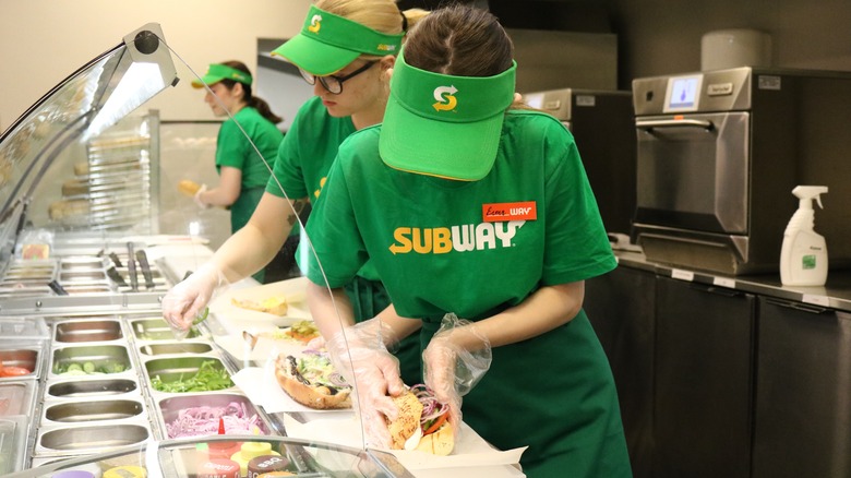 sandwich artists making wrapping subs