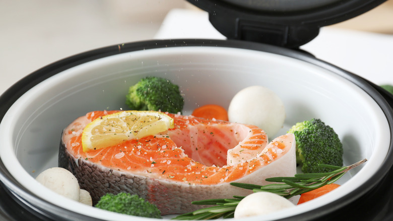 Salmon, eggs, vegetables in steamer basket