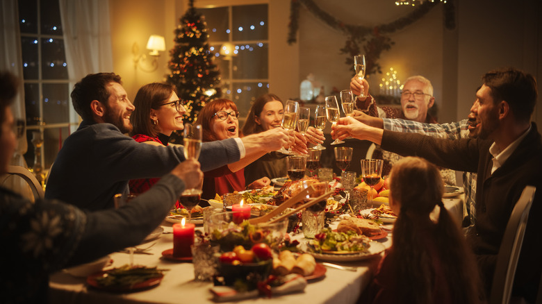 Family raising glasses in a toast at Christmas dinner