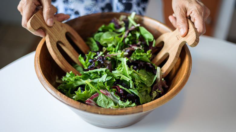 person tossing salad