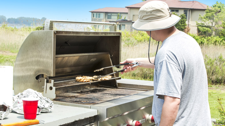 Person cooking on gas grill